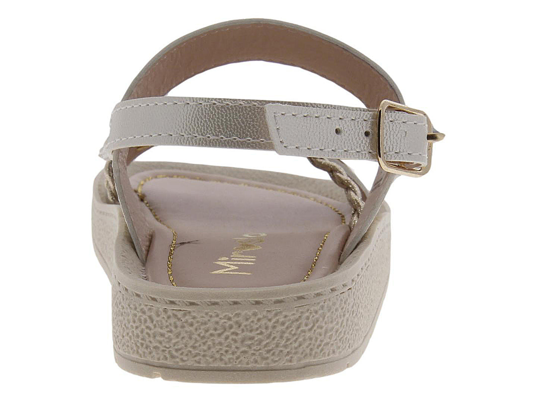 Sandalia para niña color beige con adornos de flores y tira trenzada dorada.