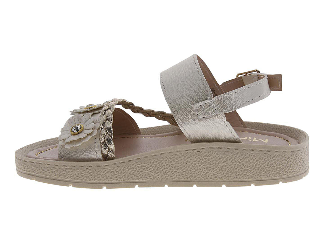 Sandalia para niña color beige con adornos de flores y tira trenzada dorada.
