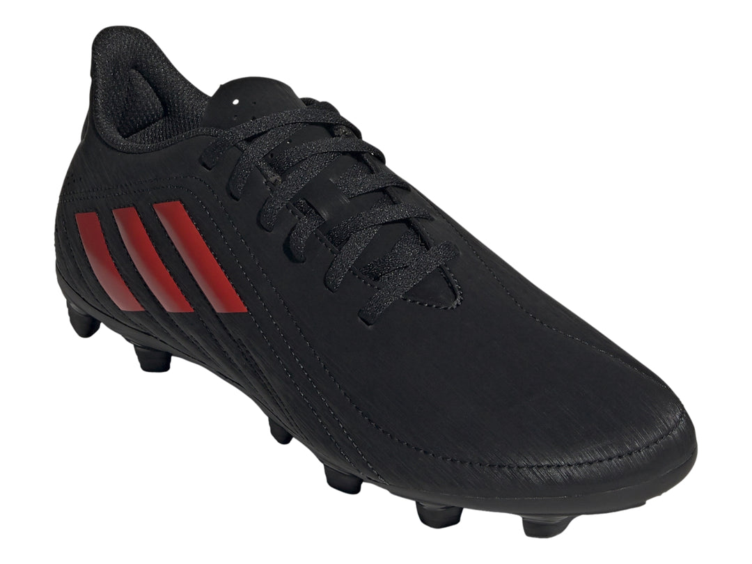 Zapato de fútbol Adidas color negro con tres franjas rojas y suela de tacos.