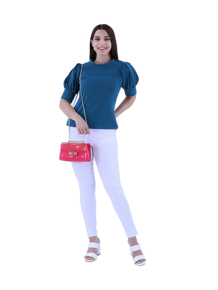 Mujer vistiendo una blusa color petróleo con mangas abullonadas y cuello redondo.