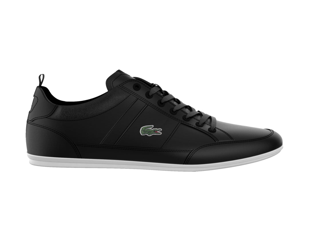 Tenis Lacoste color negro con suela blanca y logotipo verde en el lateral.