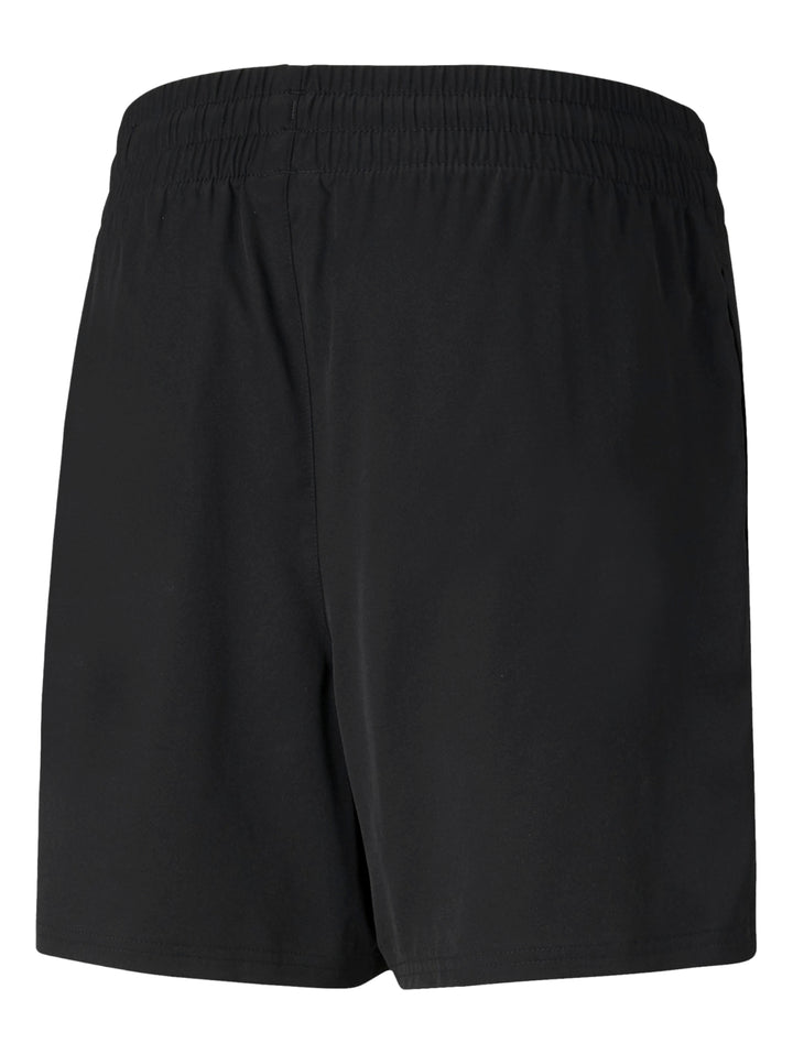Hombre vistiendo shorts deportivos PUMA de color negro, corte corto y tejido técnico.