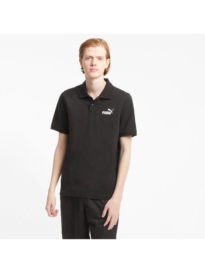 Hombre vistiendo una playera polo PUMA de color negro con logotipo blanco en el pecho.