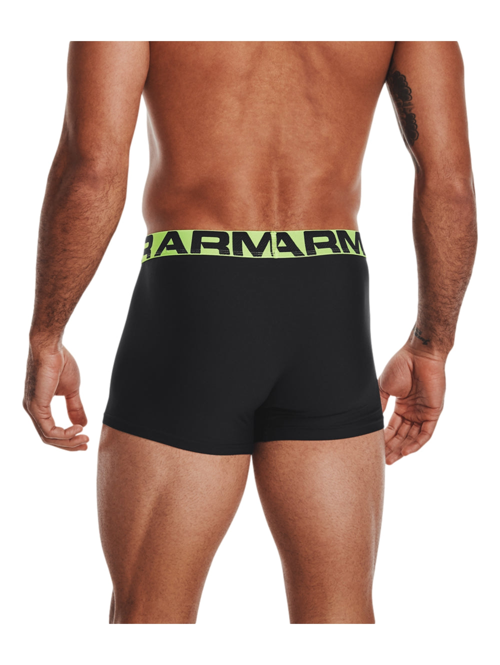 Hombre vistiendo boxer negro de Under Armour con banda elástica verde lima.