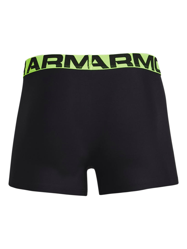 Hombre vistiendo boxer negro de Under Armour con banda elástica verde lima.