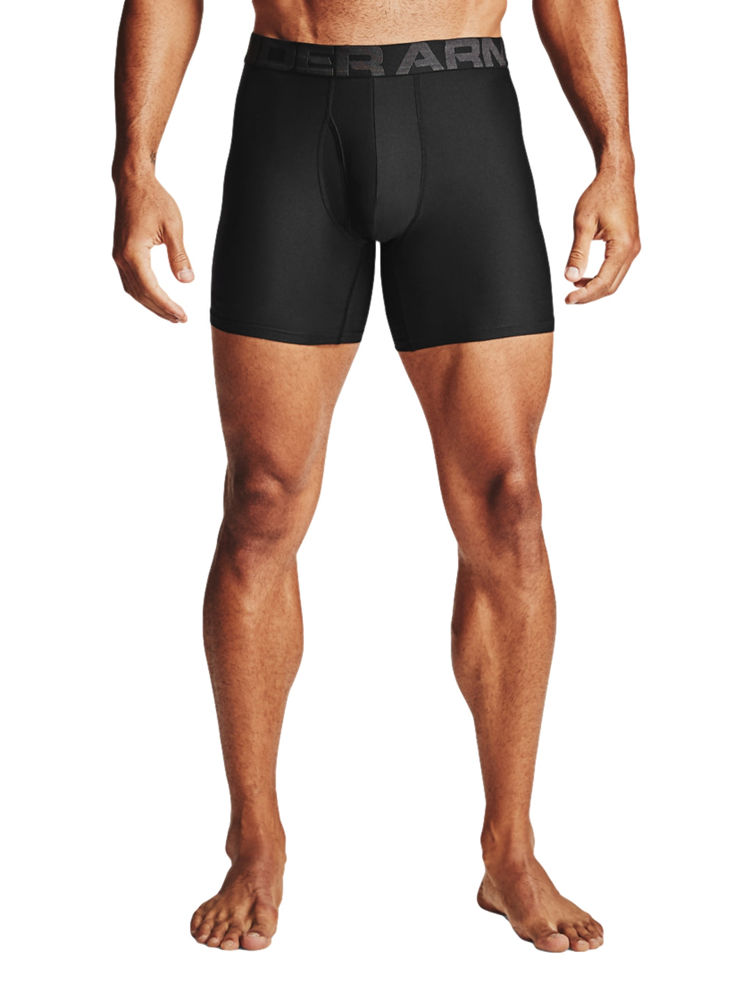 Hombre vistiendo boxers negros ajustados de la marca Under Armour.