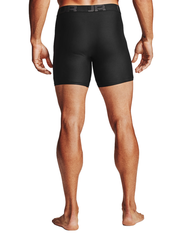 Hombre vistiendo boxers negros ajustados de la marca Under Armour.