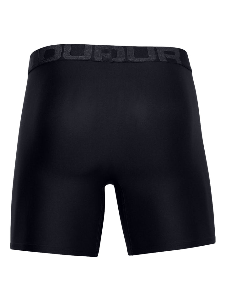 Hombre vistiendo boxers negros ajustados de la marca Under Armour.