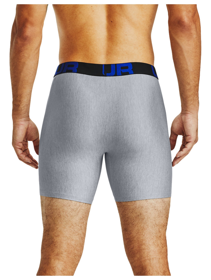 Hombre vistiendo boxer gris de Under Armour con banda elástica azul marino.