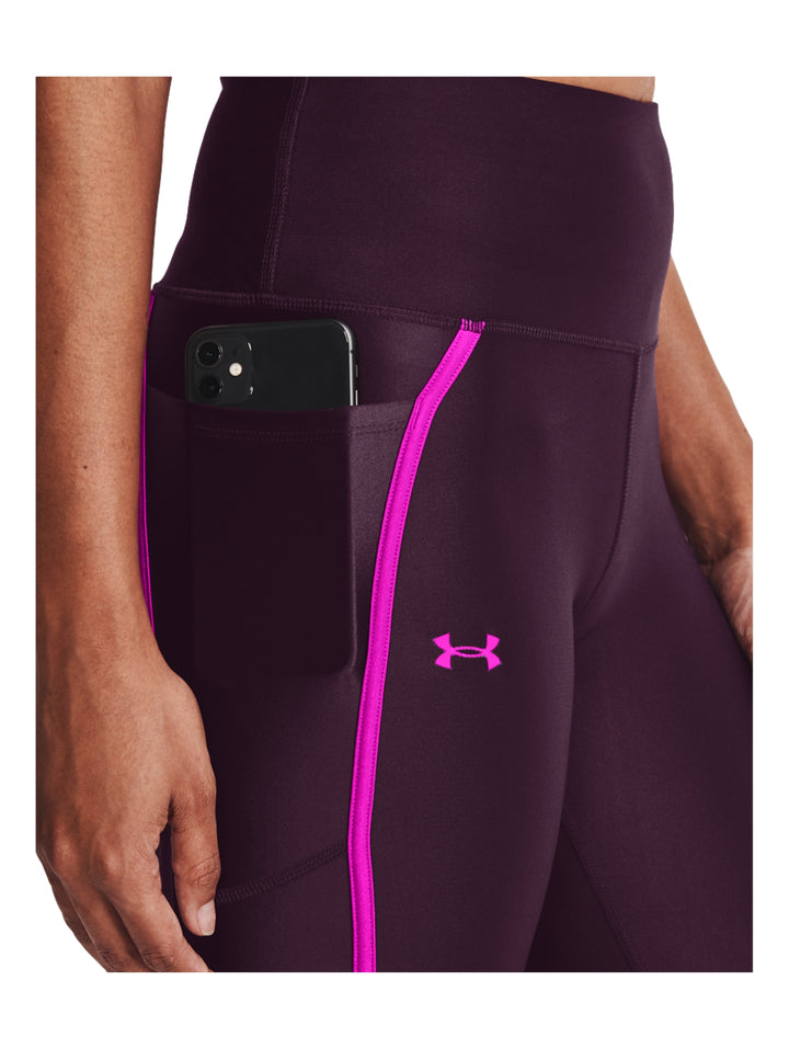 Mujer vistiendo mallas deportivas Under Armour color morado con franjas laterales en rosa brillante.