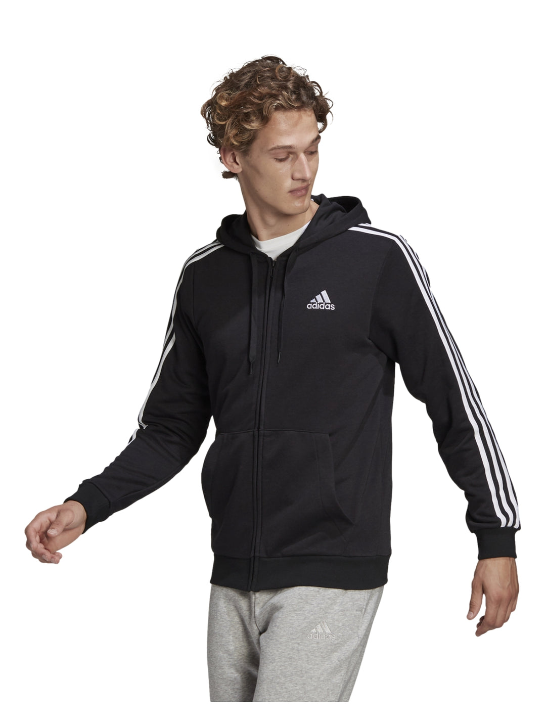 Hombre vistiendo sudadera deportiva Adidas negra con capucha, cierre completo y tres franjas blancas en las mangas.