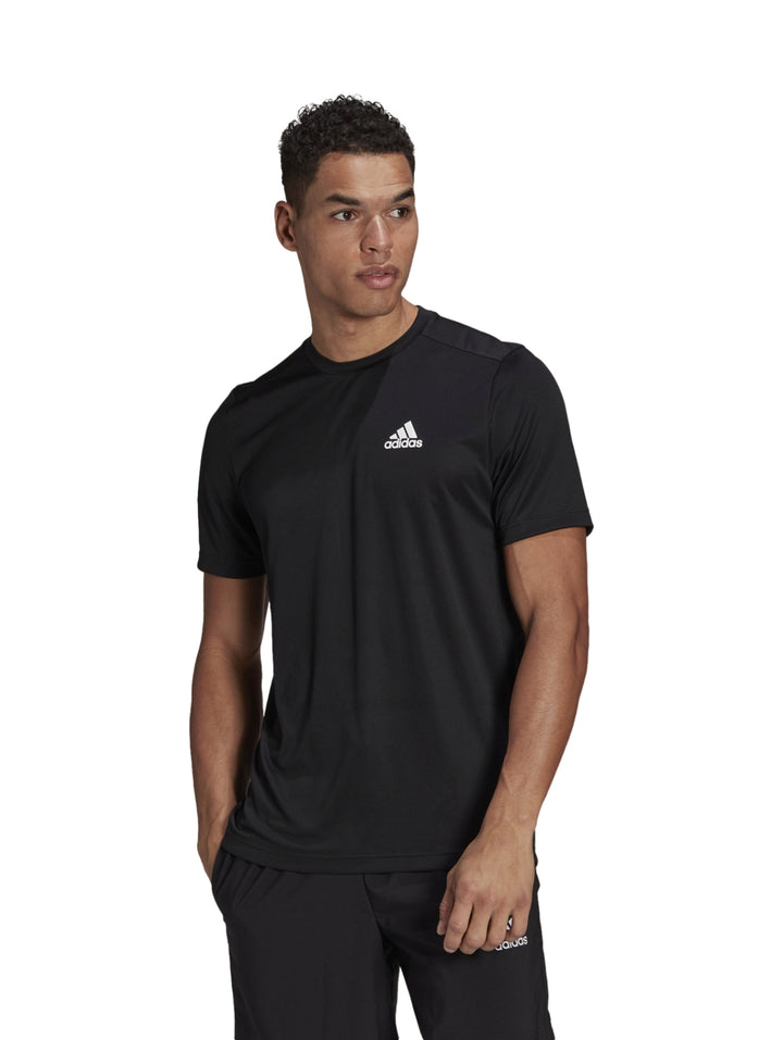 Hombre vistiendo playera deportiva Adidas de color negro con logo blanco en el pecho.