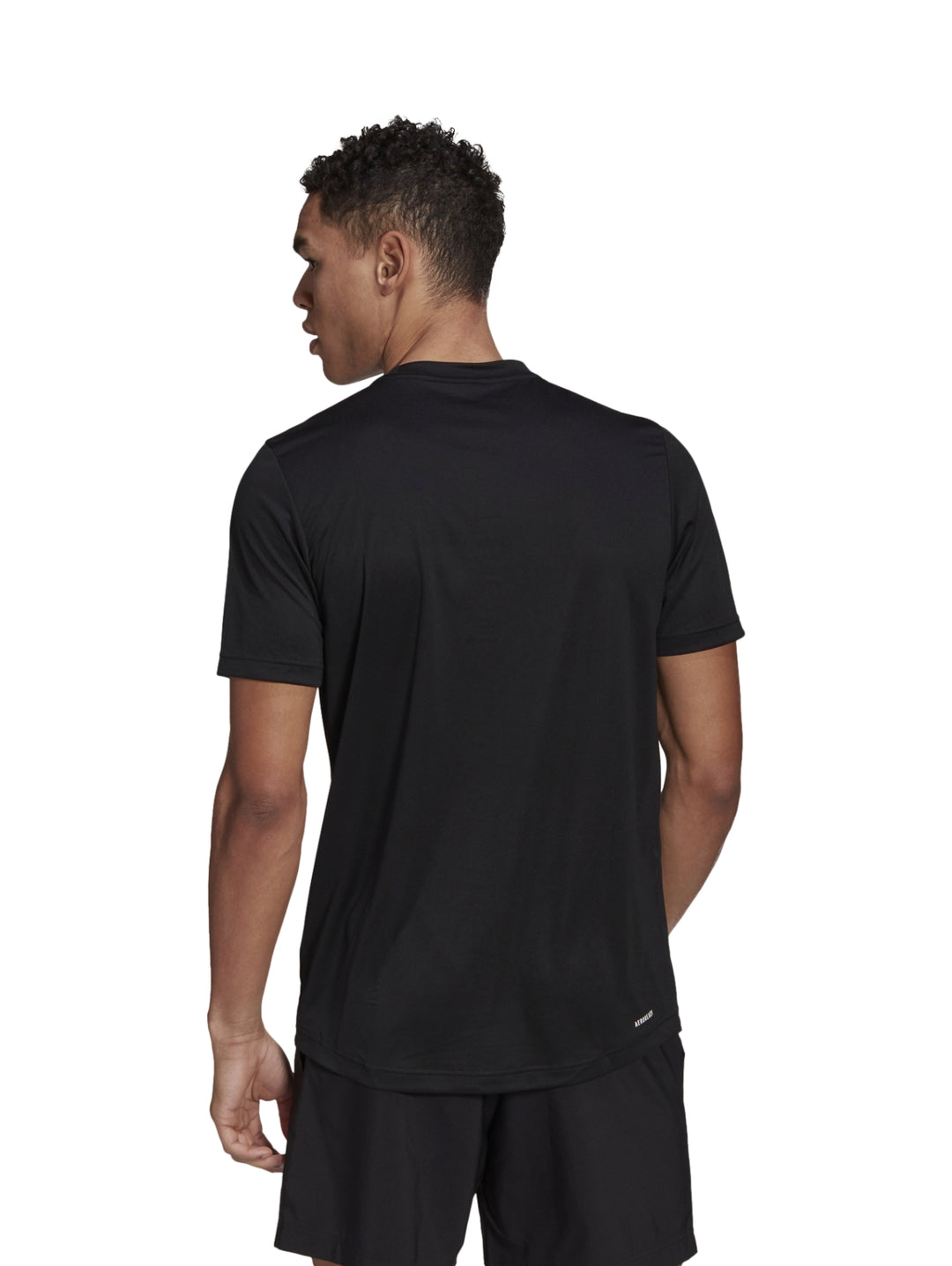 Hombre vistiendo playera deportiva Adidas de color negro con logo blanco en el pecho.