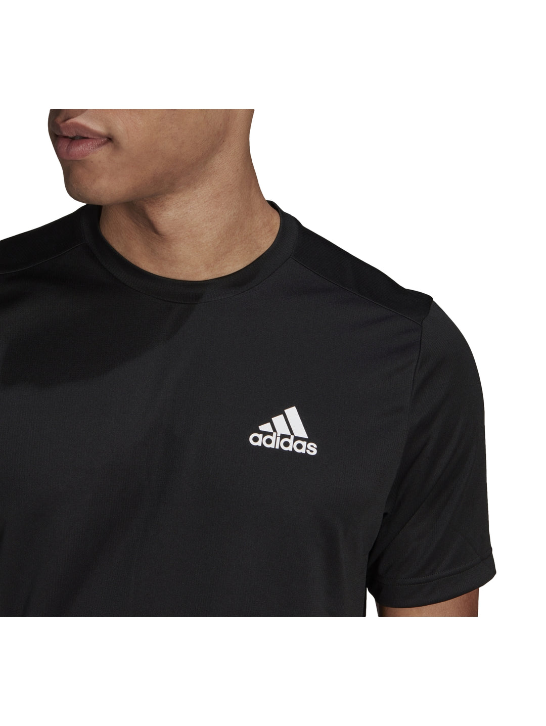 Hombre vistiendo playera deportiva Adidas de color negro con logo blanco en el pecho.
