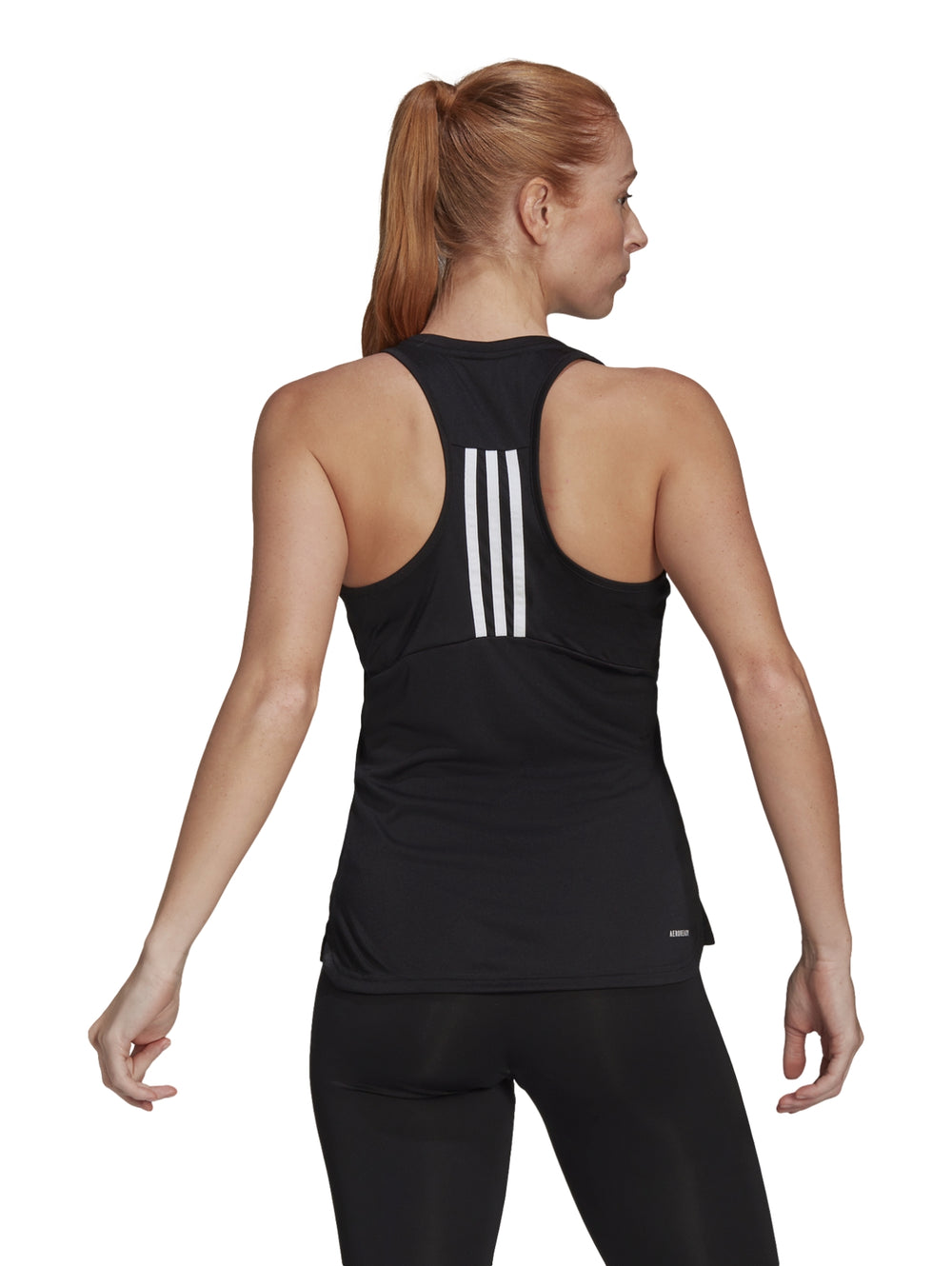Mujer vistiendo camiseta deportiva negra sin mangas de la marca Adidas con logotipo blanco en el pecho.