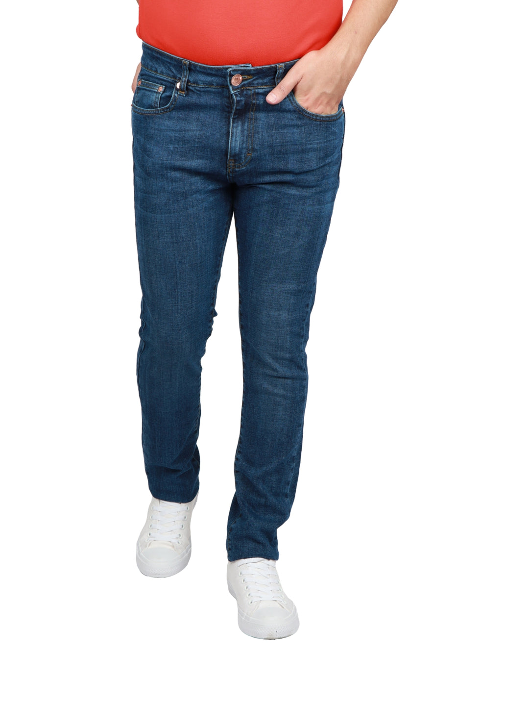 Jeans azul oscuro de corte slim para hombre con calzado blanco.