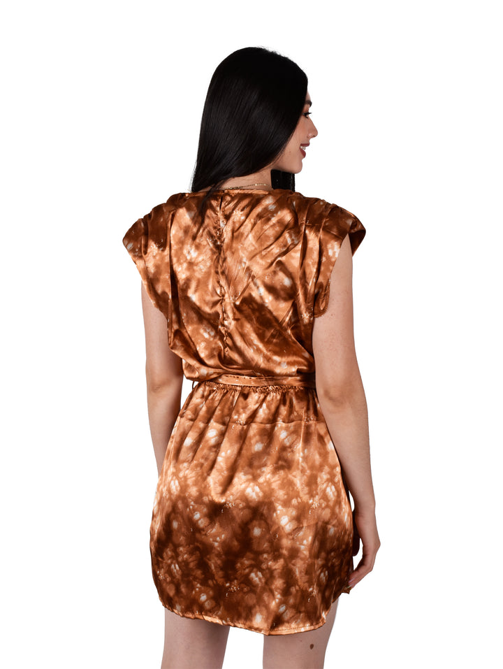 Mujer con vestido corto color bronce satinado con lazo en la cintura y hombreras.
