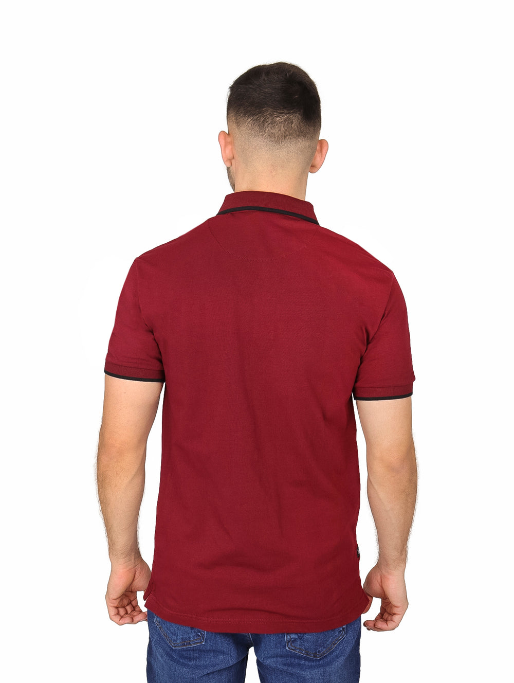 Hombre vistiendo playera polo color vino con detalles negros en cuello y mangas.