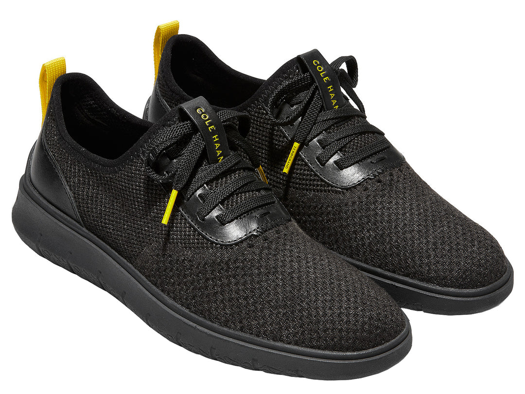 Tenis negros Cole Haan Generation Zerogrand Stitchlite para hombre con detalles amarillos.