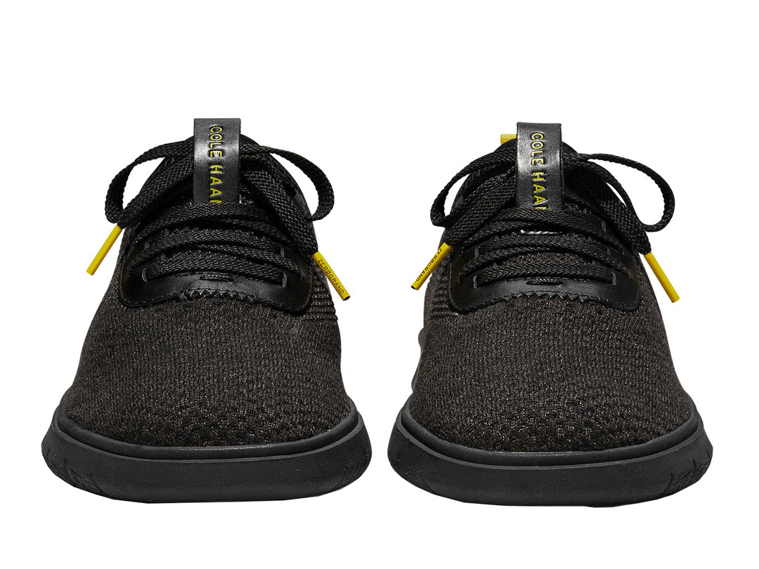 Tenis negros Cole Haan Generation Zerogrand Stitchlite para hombre con detalles amarillos.
