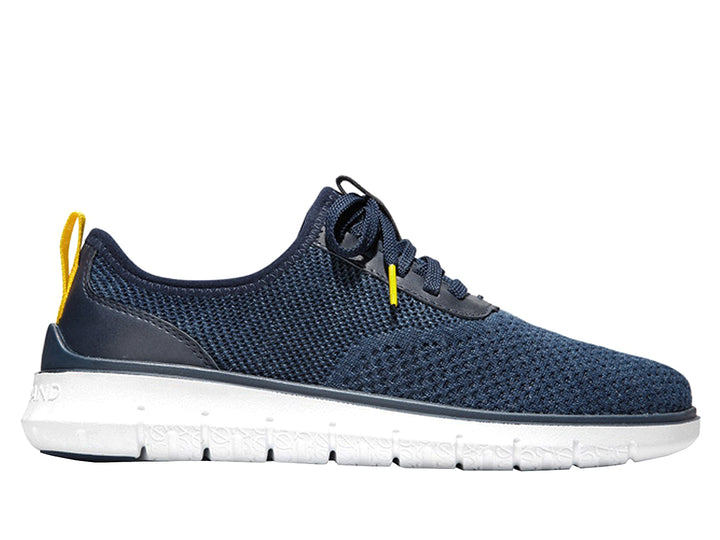 Tenis deportivos Cole Haan color azul marino con suela blanca y detalles en amarillo.