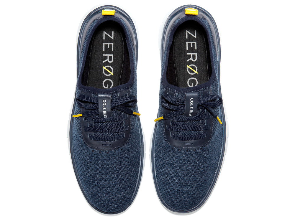 Tenis deportivos Cole Haan color azul marino con suela blanca y detalles en amarillo.