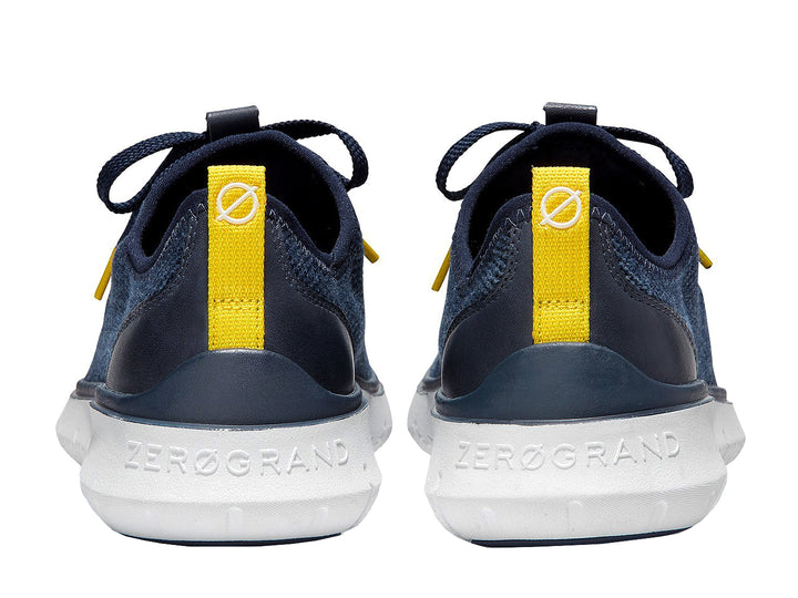 Tenis deportivos Cole Haan color azul marino con suela blanca y detalles en amarillo.