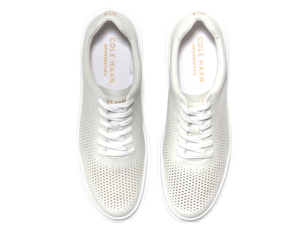 Tenis blancos Cole Haan Grandpro Rally Perf para hombre con detalles perforados y suela blanca.