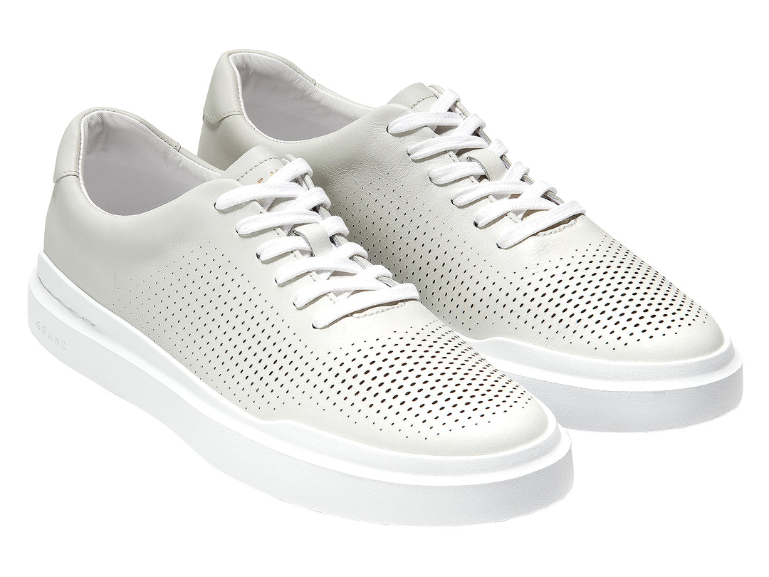 Tenis blancos Cole Haan Grandpro Rally Perf para hombre con detalles perforados y suela blanca.