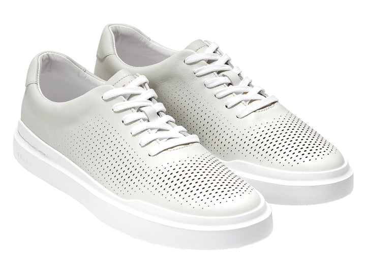 Tenis blancos Cole Haan Grandpro Rally Perf para hombre con detalles perforados y suela blanca.