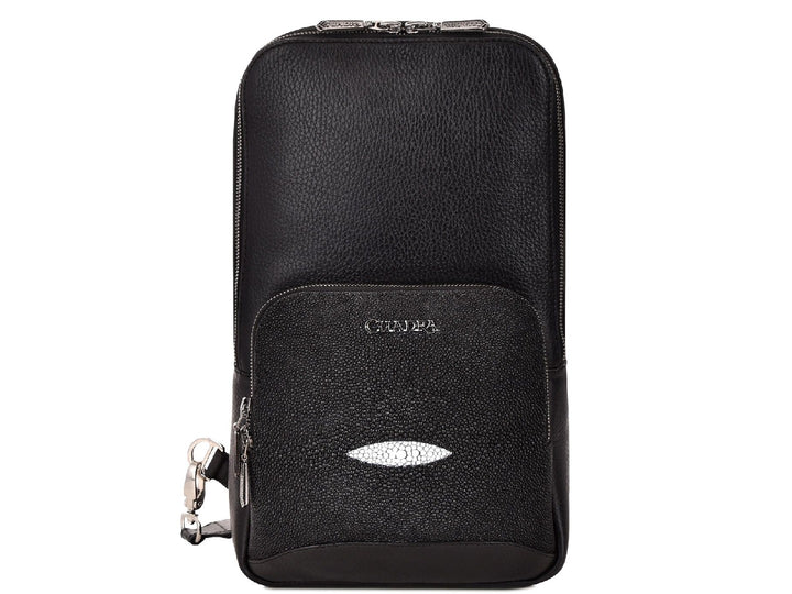 Mochila de cuero negro marca Cuadra con panel frontal de piel de mantarraya y detalles plateados.