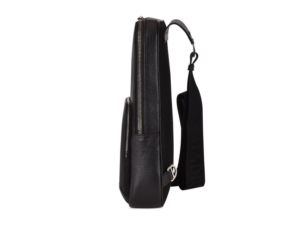 Mochila de cuero negro marca Cuadra con panel frontal de piel de mantarraya y detalles plateados.