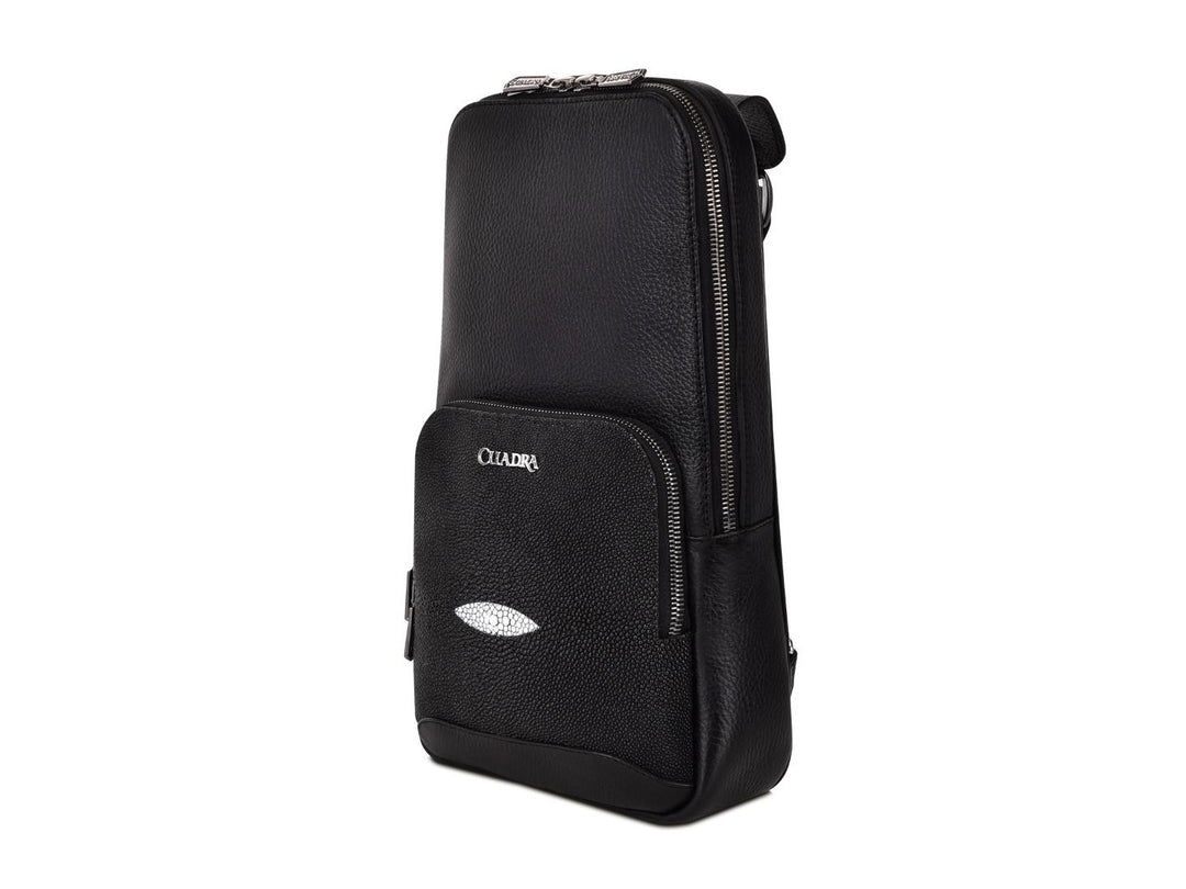 Mochila de cuero negro marca Cuadra con panel frontal de piel de mantarraya y detalles plateados.