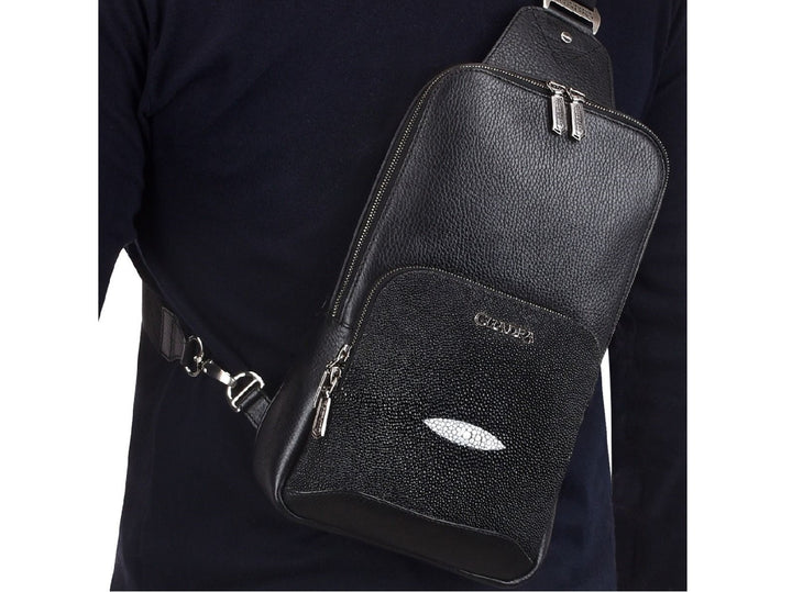 Mochila de cuero negro marca Cuadra con panel frontal de piel de mantarraya y detalles plateados.