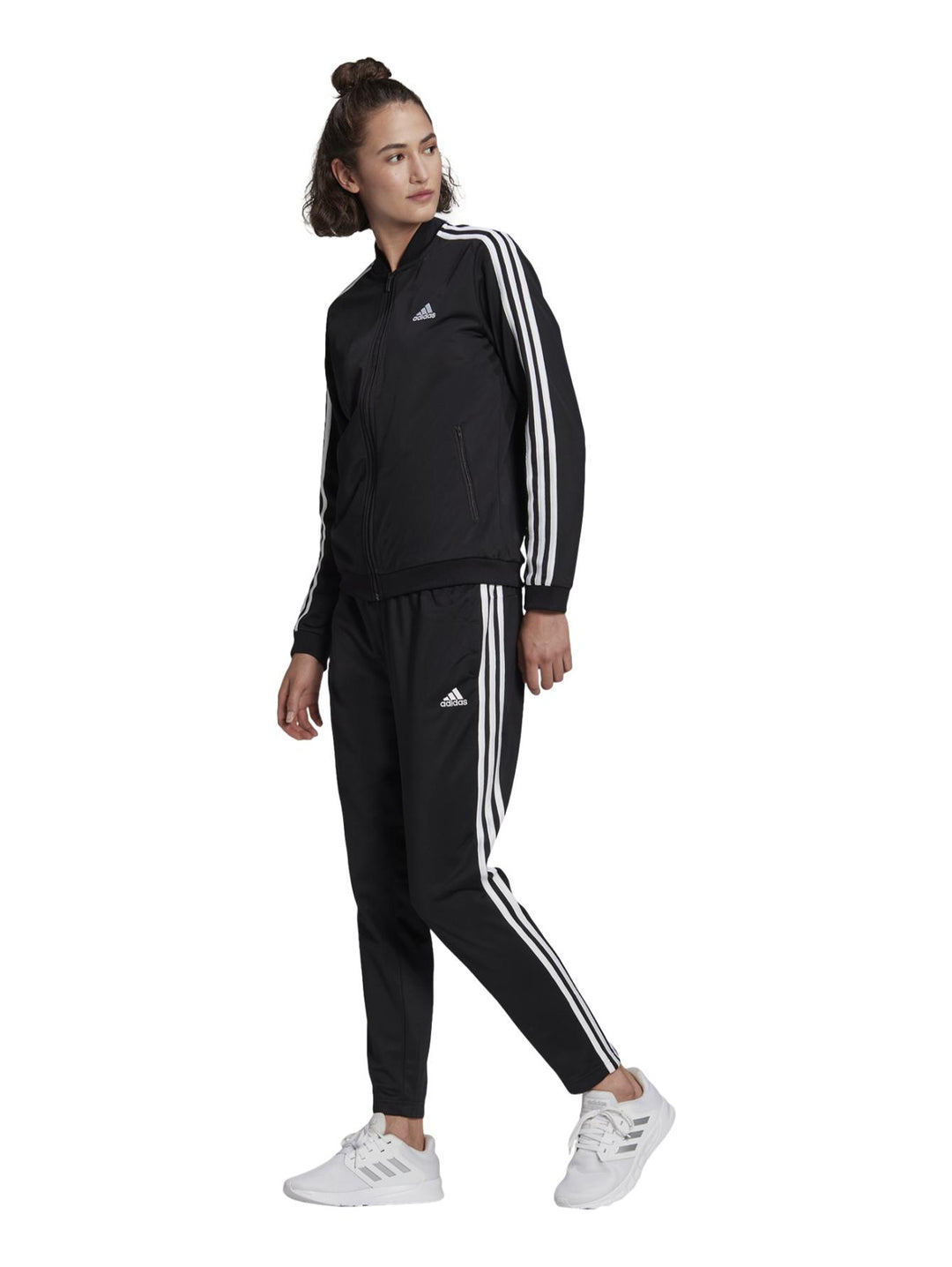 Conjunto deportivo Adidas negro para mujer con rayas blancas laterales y calzado blanco.