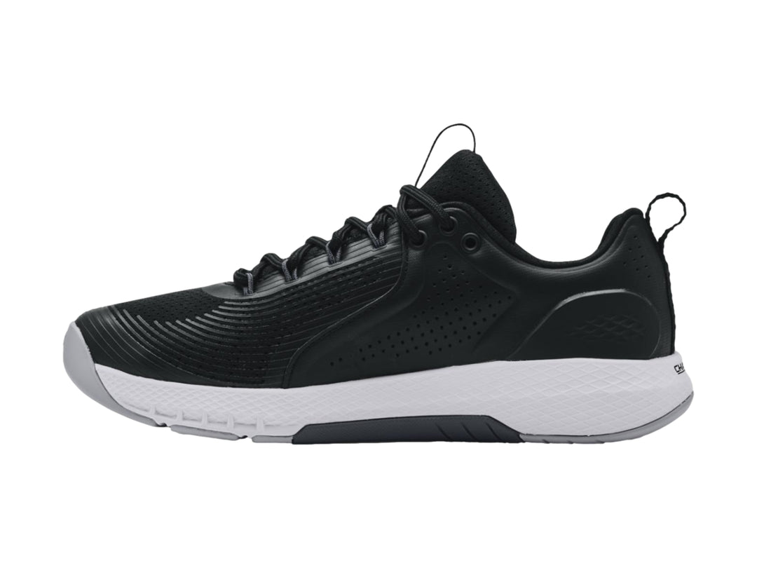 Tenis deportivos Under Armour Charged Commit TR 3 en color negro con suela blanca y logo lateral blanco.