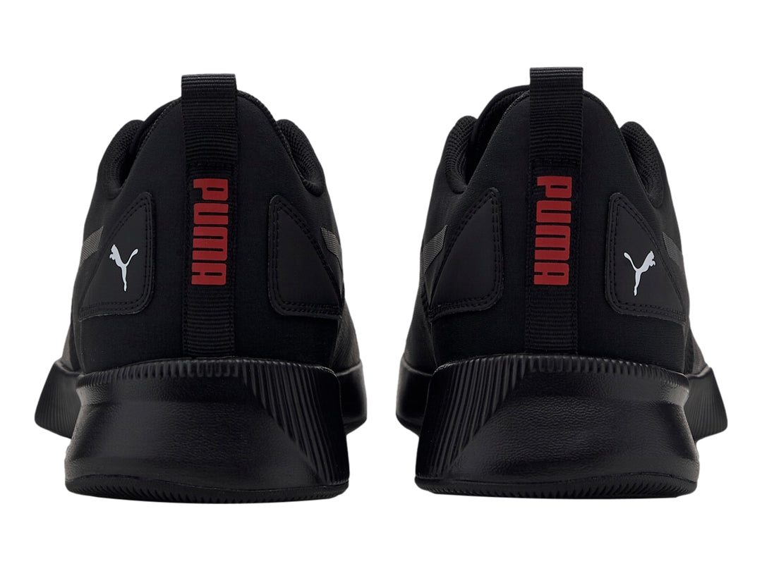 Tenis deportivo PUMA Flyer Runner color negro con detalles en rojo, vista lateral sobre fondo blanco.