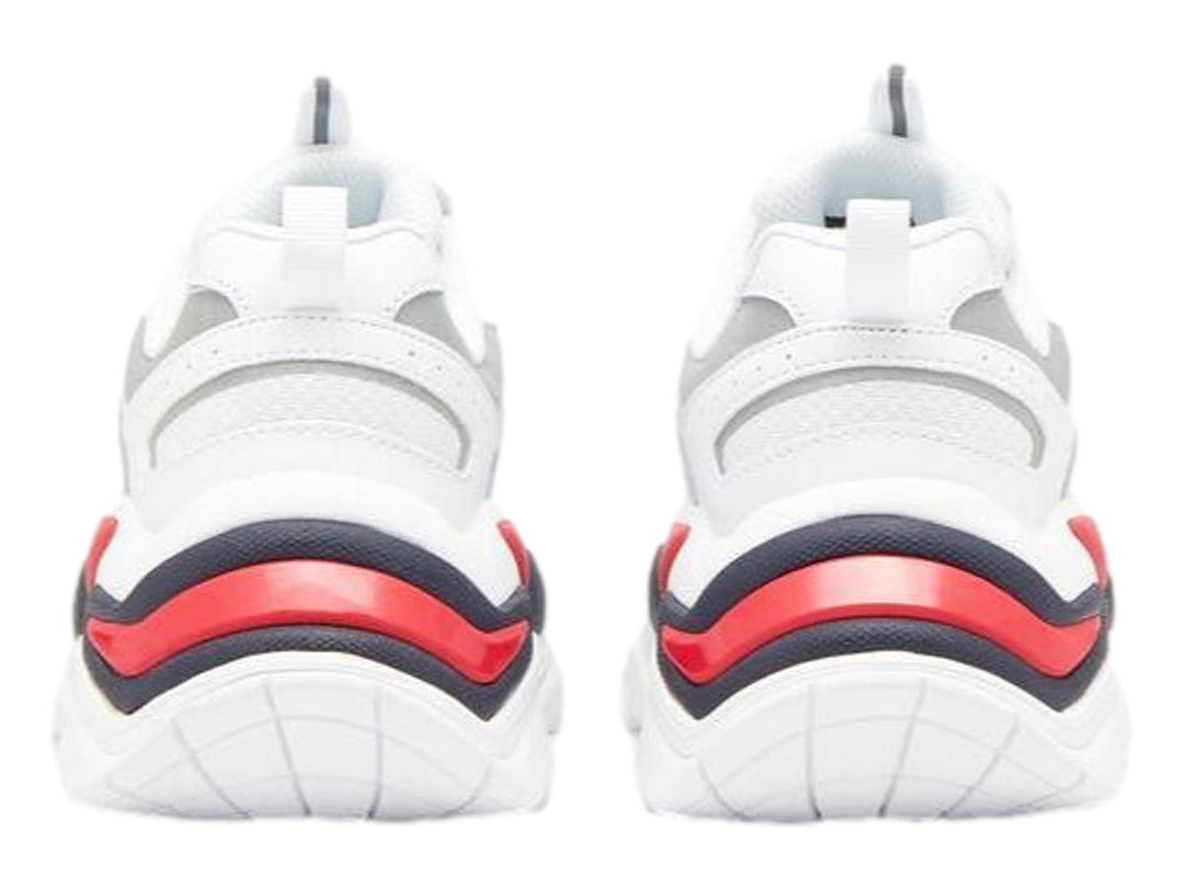 Tenis FILA blancos con detalles en azul marino y rojo, diseño robusto y suela gruesa.