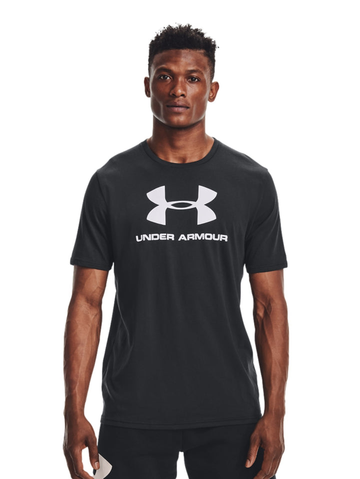 Hombre vistiendo camiseta deportiva negra de manga corta con logotipo blanco de Under Armour en el pecho.