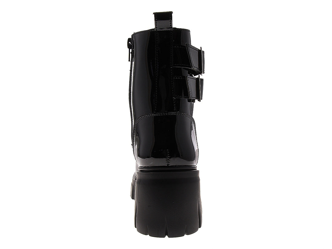 Bota de charol negro con plataforma gruesa y correas con tachuelas plateadas.