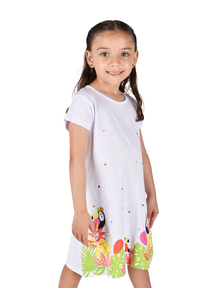Vestido blanco para niña con estampado tropical de tucanes y hojas verdes en la parte inferior.
