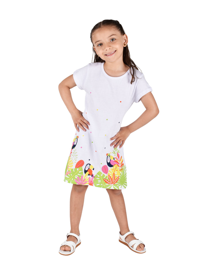 Vestido blanco para niña con estampado tropical de tucanes y hojas verdes en la parte inferior.