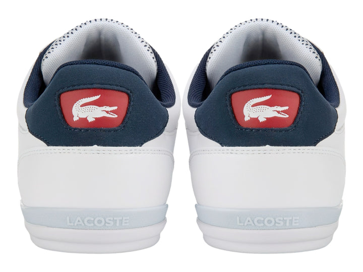Tenis deportivos Lacoste blancos con franjas laterales en azul marino y rojo.