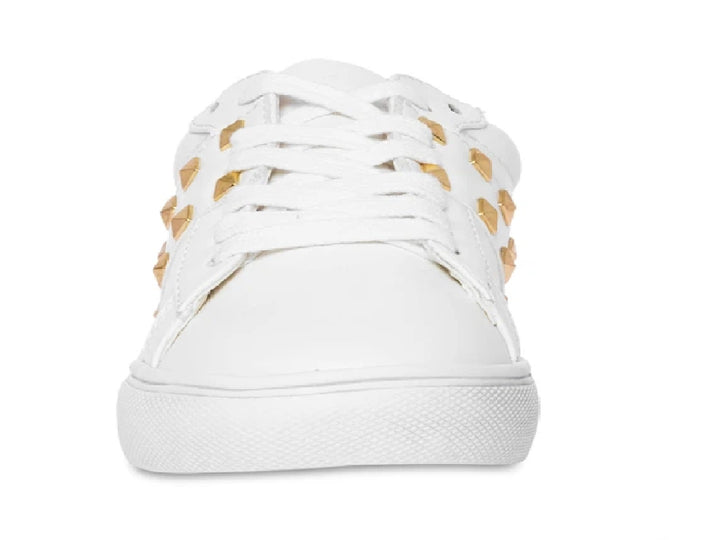 Tenis blancos Steve Madden para niño con detalles de tachuelas doradas en el lateral y suela blanca.