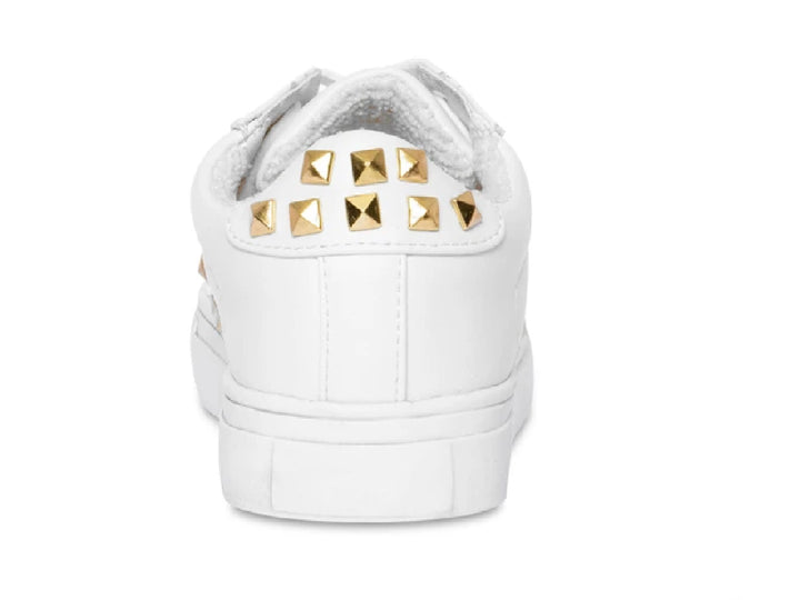 Tenis blancos Steve Madden para niño con detalles de tachuelas doradas en el lateral y suela blanca.