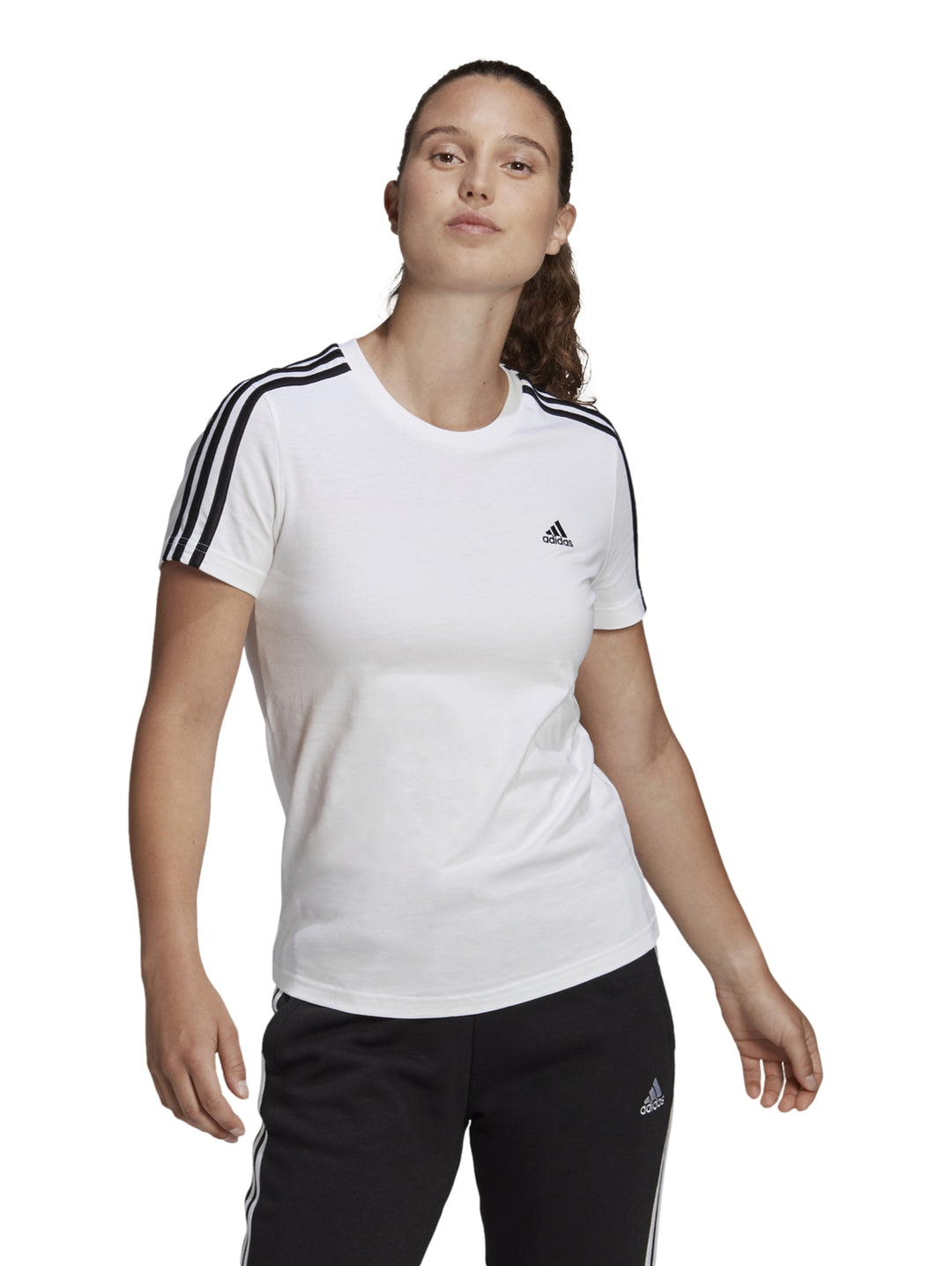 Mujer vistiendo playera deportiva blanca Adidas con tres franjas negras en los hombros.