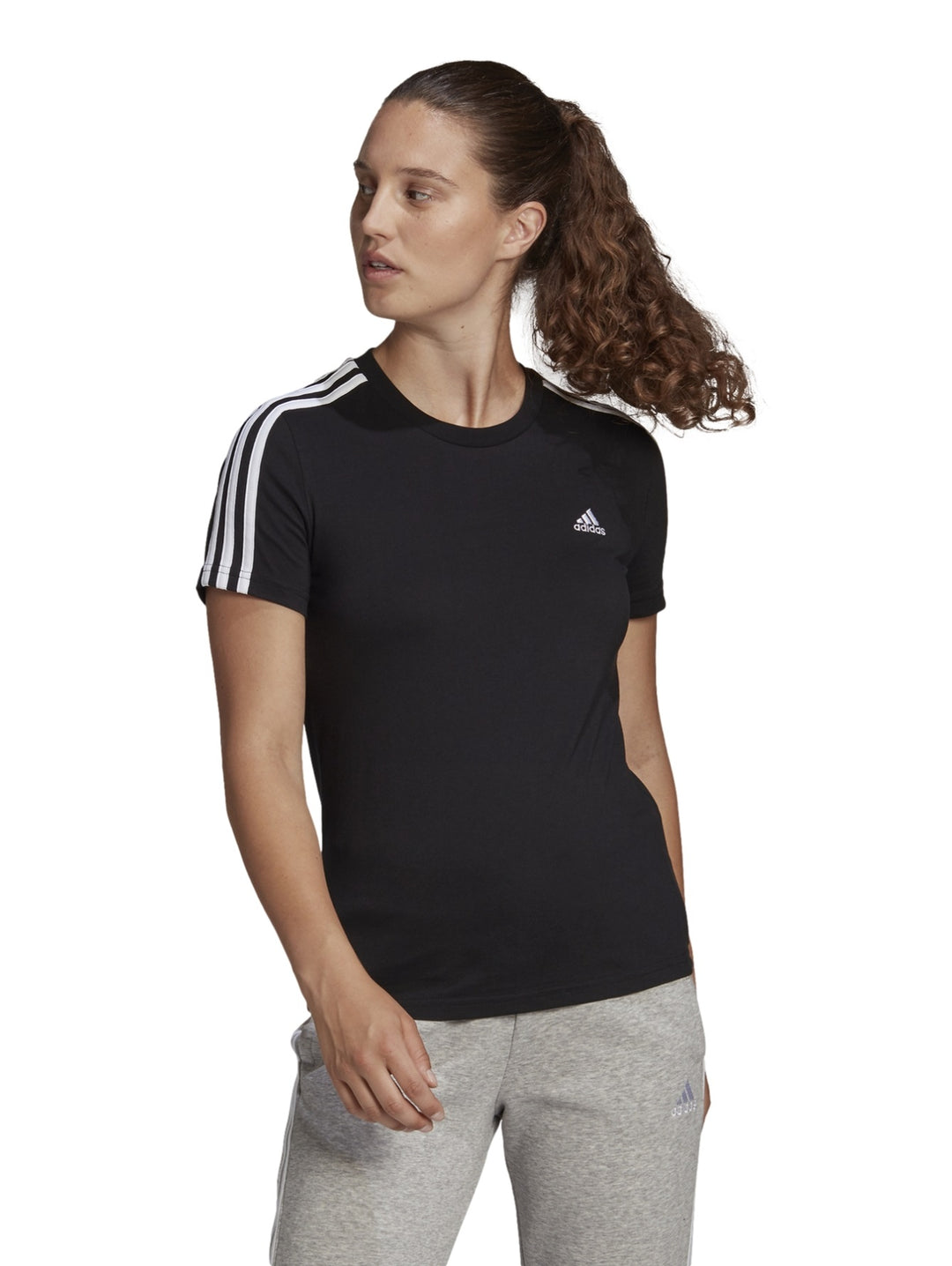 Mujer vistiendo playera deportiva Adidas color negro con tres franjas blancas en los hombros.