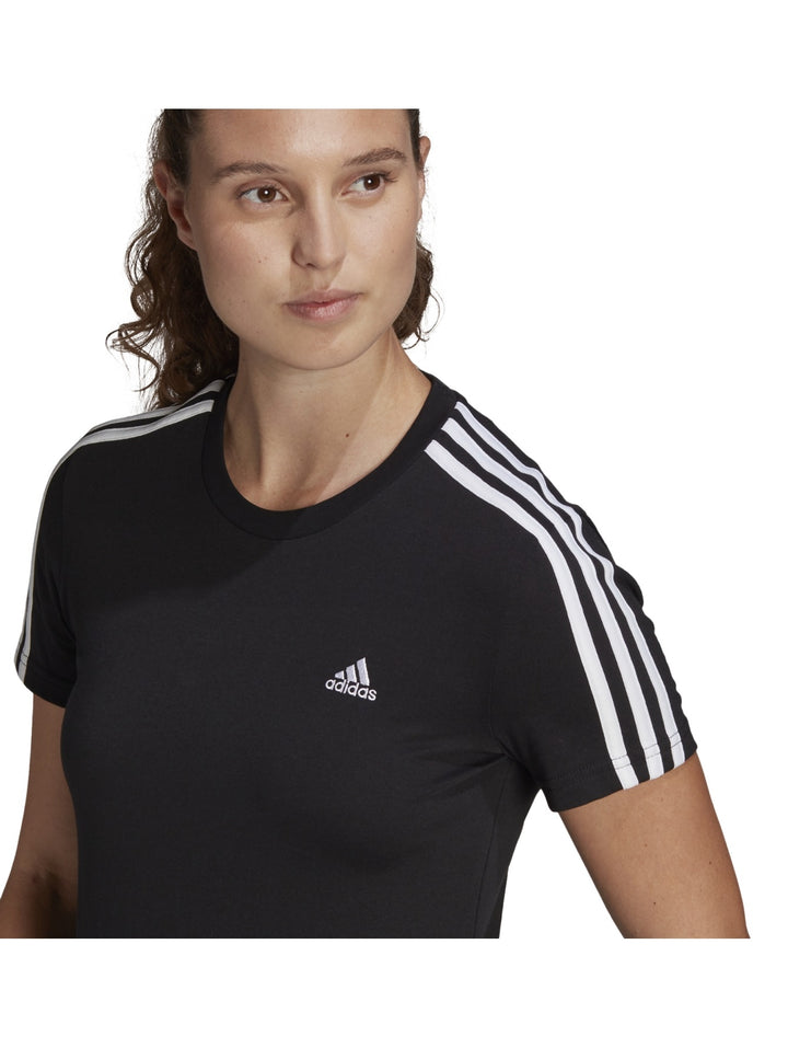 Mujer vistiendo playera deportiva Adidas color negro con tres franjas blancas en los hombros.
