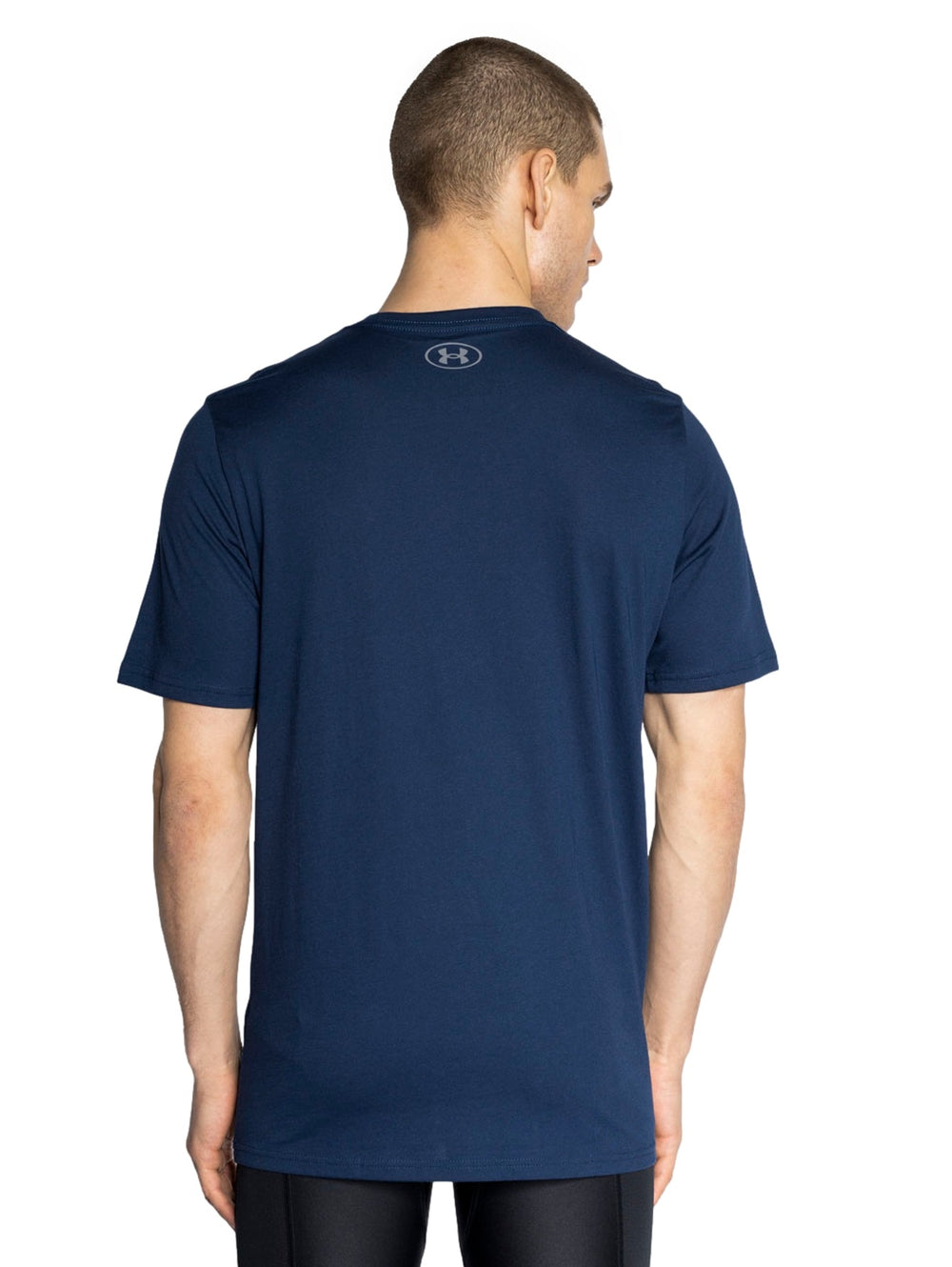 Hombre vistiendo playera deportiva Under Armour de color azul marino con logotipo blanco en el pecho.