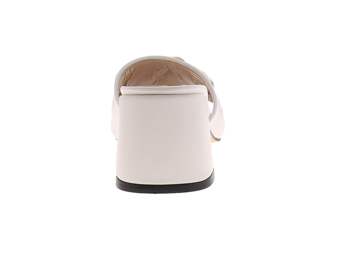 Sandalia beige de tacón cuadrado con detalle de cadena dorada en la parte superior.